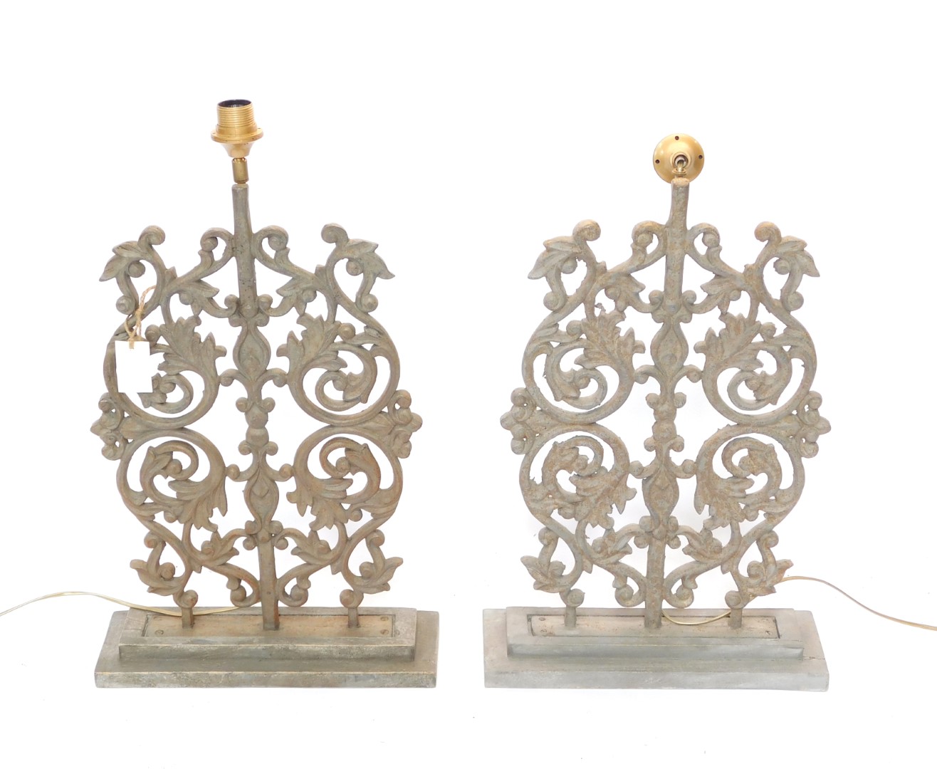 A pair of 20thC iron table lamps, each set with a regal style arrangement of scrolls, orbs and flowe