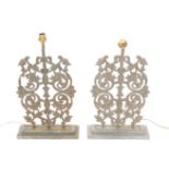 A pair of 20thC iron table lamps, each set with a regal style arrangement of scrolls, orbs and flowe