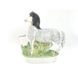 A Staffordshire late 19thC pottery flat back figure of a zebra, modelled in standing pose, facing le