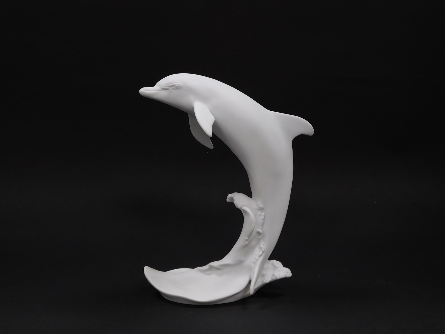A Kaiser white matt bisque porcelain figure, modelled as a Dolphin, no 654., printed and impressed m