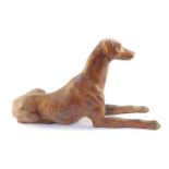 A hollow cast brass figure of a greyhound, with a patinated finish, modelled in recumbent pose, 56cm