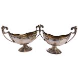 A pair of Victorian silver salts of twin handled fluted pedestal form, James Deakin and Sons, Cheste
