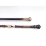 An Anglo Indian early 20thC beech and ebony walking stick, decorated with an entwined bone figure of