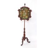 A Victorian mahogany pole screen, the shaped central section embroidered with a petit point floral d