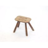 A Victorian oak and elm milking stool, raised on four fluted legs, 25.5cm wide.