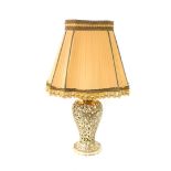 A brass table lamp, of pierced baluster form, decorated with scrolling leaves, with a shade, 76cm hi