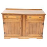 A 20thC oak sideboard, the moulded top raised above two frieze drawers, with fitted interior for cut