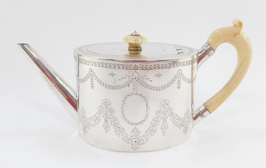 A Victorian silver teapot, the oval body with ivory handle and knop, plain spout, chased with garlan