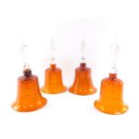 Four Victorian deep amber glass bells, with clear glass handles, 30cm high. (AF)