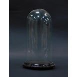 A cut glass dome on an ebonised wooden stand, 28cm high.