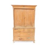 A Victorian pine cupboard, the fixed cornice raised above a pair of carved arched doors revealing fi