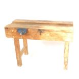 An early 20thC pine work bench, of shaped form on block stiles, joined by vertical stretchers, with