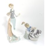 A Lladro porcelain figure modelled as a girl washing a dog in a tub, and another figure modelled as