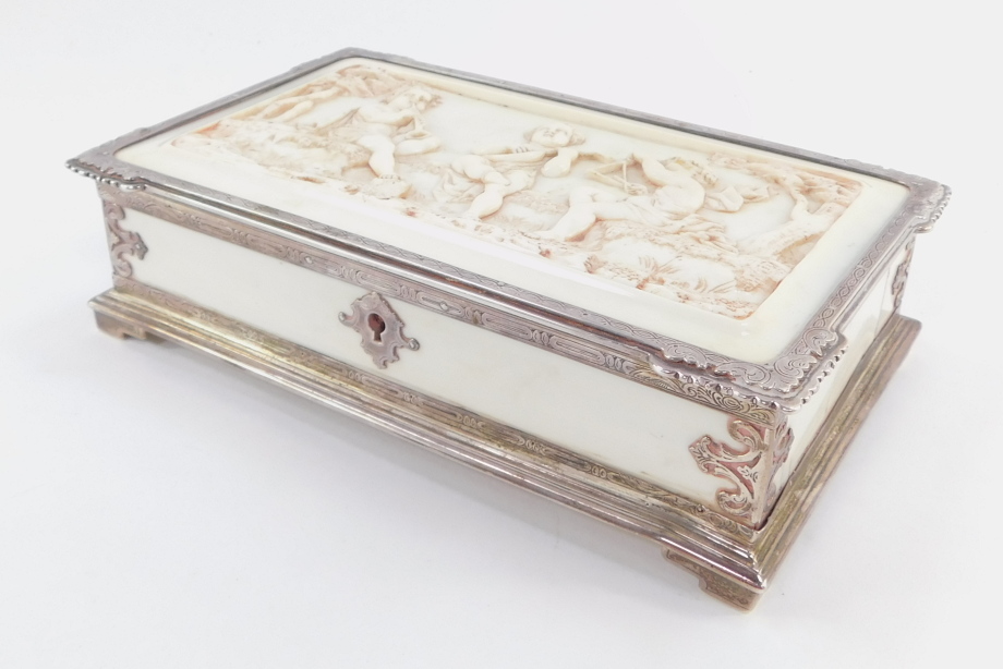 A Victorian silver and ivory box, of rectangular form, the lid heavily carved with three cherubs pla