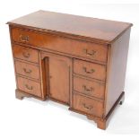 A George III style mahogany radiogram cabinet kneehole desk, of rectangular form with hinged lid and
