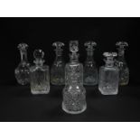 A set of three cut glass decanters, with mushroom shaped stoppers, a bell shaped decanter and stoppe