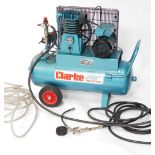 A Clarke industrial compressor, with mesh work section, additional pipes and truckle base, model PE1