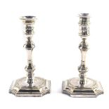 A pair of George I style silver plated candlesticks, each with removable pressed sconces, urn finial