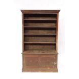A Victorian oak cupboard bookcase, the out swept pediment over four open shelves, above a pair