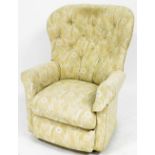 An upholstered rocker armchair, in cream floral upholstery, on castors, 100cm high, 72cm wide, 74cm