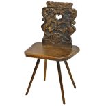 An unusual and heavily carved chair the back heavily carved with a pierced heart flanked by two warr