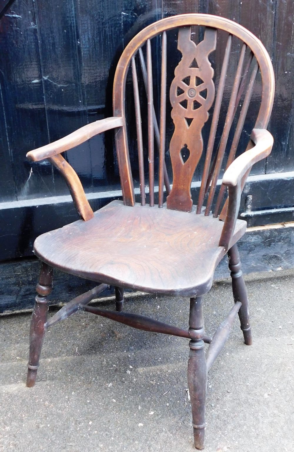 A wheel back Windsor elbow chair, with shaped elm seat.