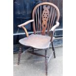 A wheel back Windsor elbow chair, with shaped elm seat.
