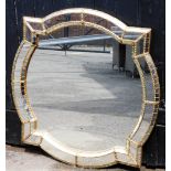 A decorative glass wall mirror, of rectangular shaped design, set with various panels and gold borde