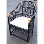 A Chinese style painted wicker armchair, the back with Chinese oval panel decoration, painted black