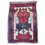 A Middle Eastern prayer rug, with border and central medallion in a red and cream ground, 76cm x 54c