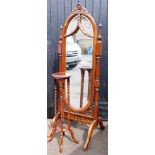 A stained oak cheval mirror, the top with rose carving and two splay leaf vines, together with an as