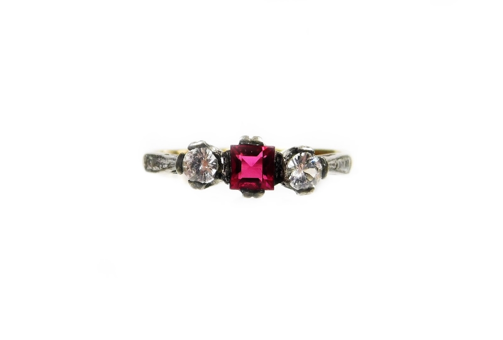 A Victorian three stone dress ring, set with garnet and two imitation diamonds, in a silver setting