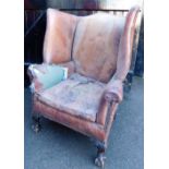 A late 19thC mahogany and leather upholstered wing back porters chair, with ball and claw feet. (AF)