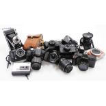 A group of cameras and camera equipment, to include a Cannon EOS, a Dixons disk 2500, Nikon 18-15mm