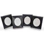 A set of four modern oval plaques, each with plaster oval centre depicting figures, in black wooden