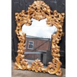 A modern gilt framed wall mirror, the arched top with feather and leaf scroll decoration, 127cm high