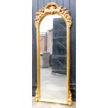 A modern gilt framed cheval type mirror, the top with arched scroll and fleur de lis pediment, with