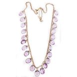 An Edwardian design amethyst graduated beaded necklace, set with twenty two oval cut amethysts, on a