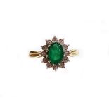An emerald and diamond cluster ring, with central oval cut emerald totalling 0.97cts, surrounded by