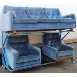 A 1970s/80s retro blue draylon sofa suite, comprising three seater sofa and two armchairs, teak turn