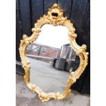 A modern gilt framed oval wall mirror, with carved frieze, 90cm high, 55cm wide.