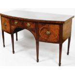 A George III mahogany bow fronted sideboard, with cross banded top raised above a frieze drawer flan