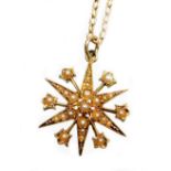 An Edwardian pendant and chain, the star pendant set with various seed pearls, in a yellow metal bac
