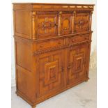 A 20thC Jacobean style oak court cupboard, the upper section with a fixed panelled cornice, raised a