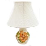 A Moorcroft baluster table lamp, coral hibiscus pattern, in cream with orange flower and green leaf