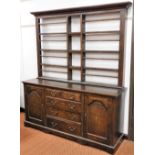 An early 19thC oak dresser, the plate rack top above two cupboard and arrangement of two short and t