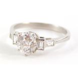 A diamond dress ring, with central round brilliant cut diamond and baguette cut diamond shoulders, t