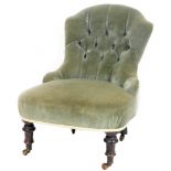 A late Victorian mahogany framed button back nursing chair, overstuffed in green to the back and sea