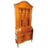 A continental walnut bureau bookcase, the eight drawer top with various open sections and cupboards,