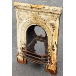 A Victorian cast iron metal fireplace, later painted in cream with design of roundels and bordered f
